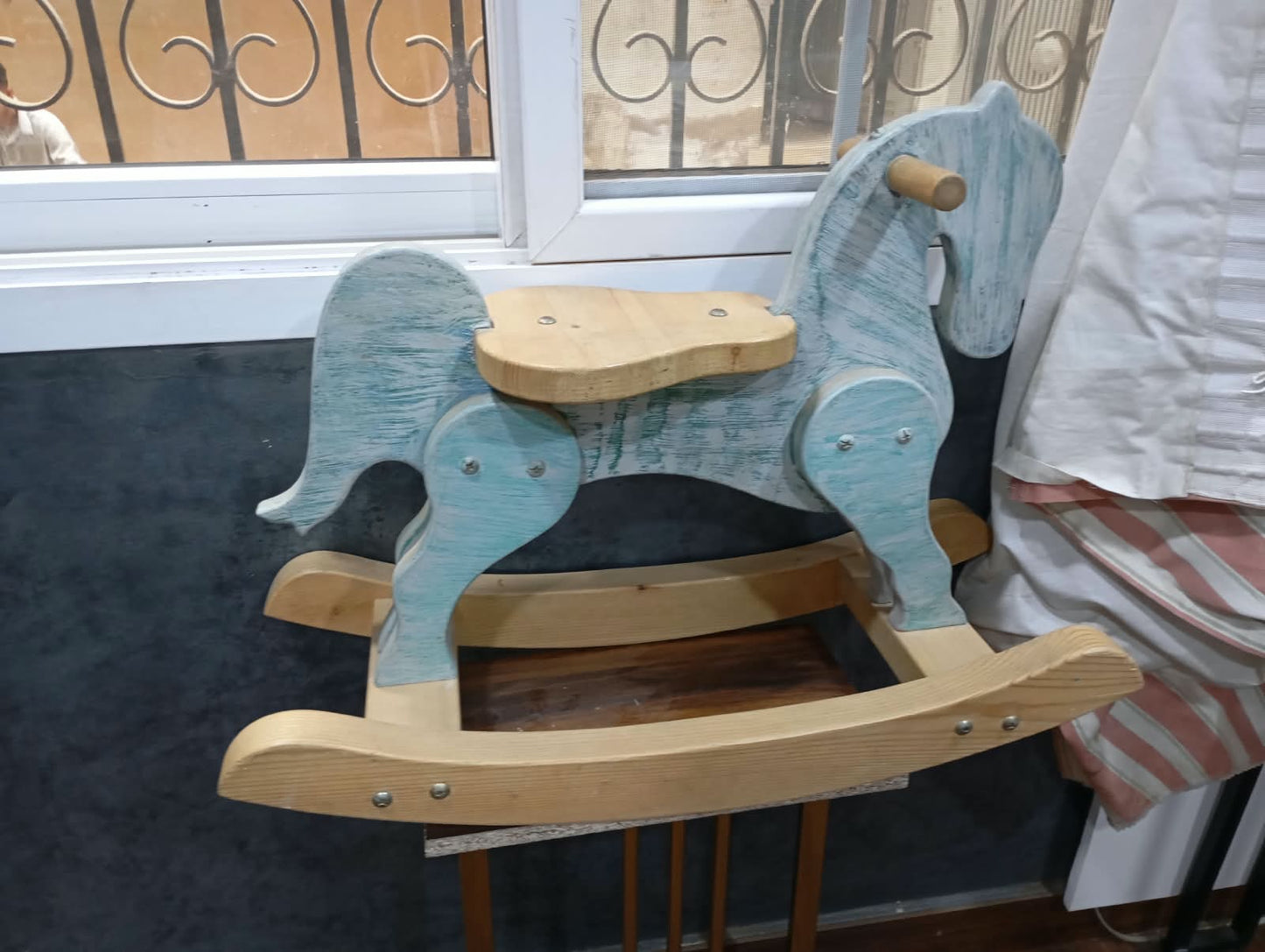 vintage-style wooden rocking horse features a distressed blue and natural wood