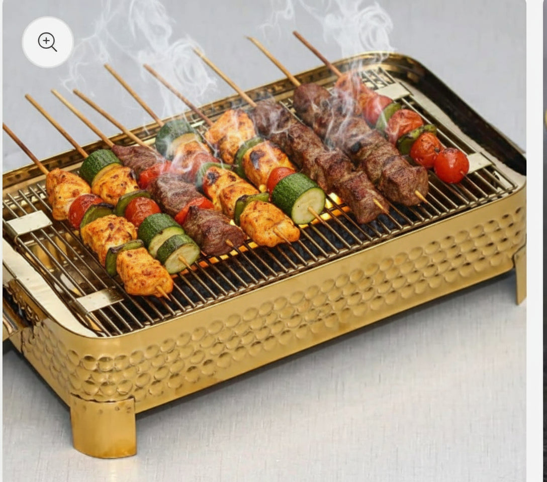 Golden hammered tabletop BBQ grill with skewers