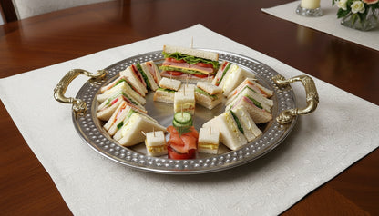 Round stainless steel tray with sandwiches and appetizers
