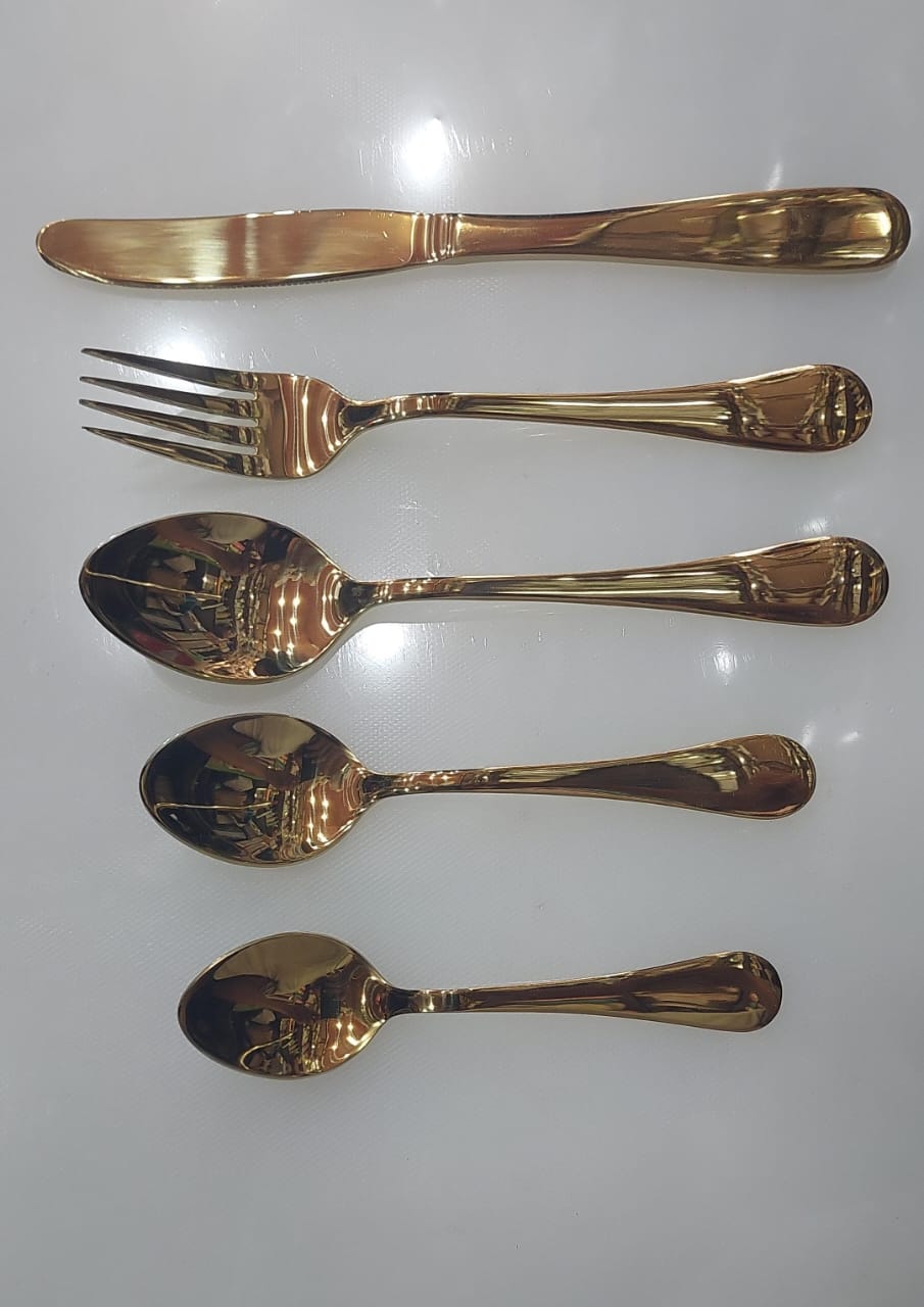 Set of gold-colored cutlery including a knife, fork, and two spoons on a white background.